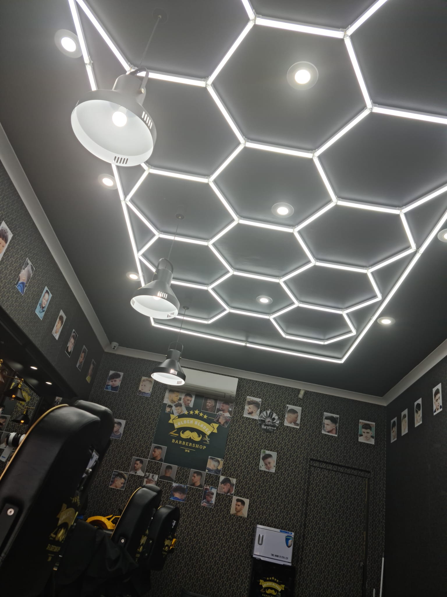 Hexagonal LED ceiling and customer photo wall inside Golden Blades 74